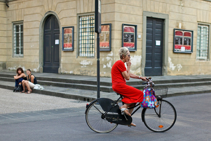 Lucca Italy pictures of a woman riding a bicycle and smoking
